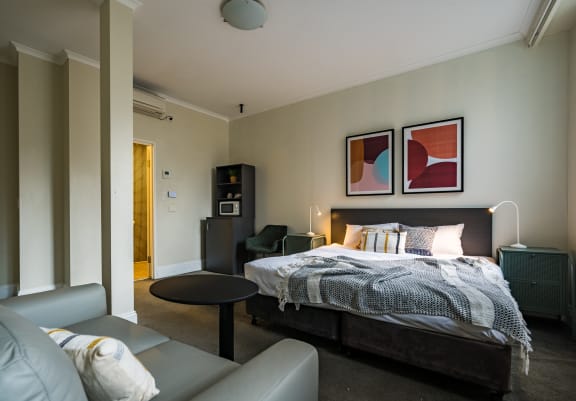 a bedroom with a bed and a couch and a table