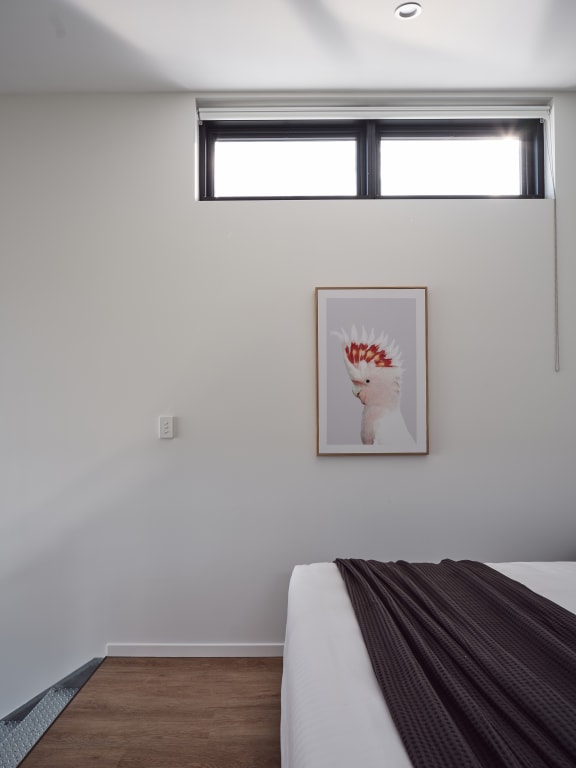 a bedroom with a bed and a painting on the wall