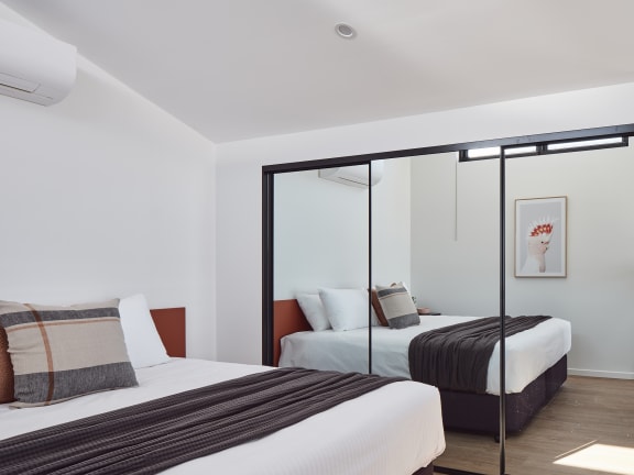 two beds in a hotel room with a large mirror