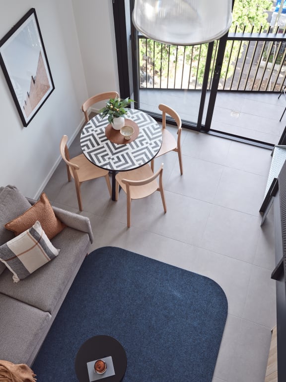 a living room with a table and a couch and a balcony