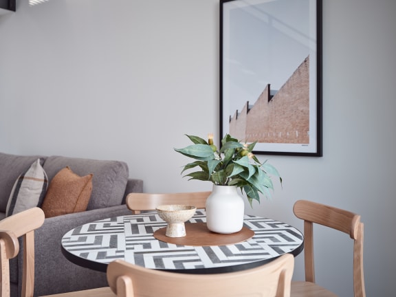 a living room with a round table with a plant on it