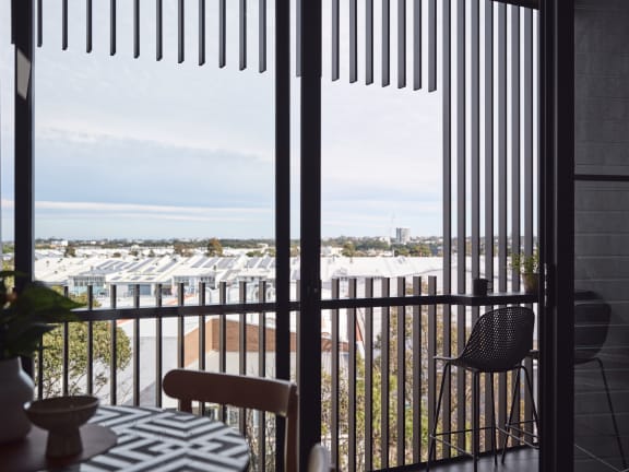 a balcony with a table and chairs and a view of the ocean