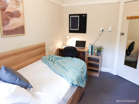 a bedroom with a bed and a desk with a laptop