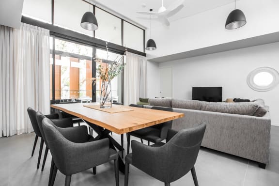 a dining room and living room with a wooden table and chairs