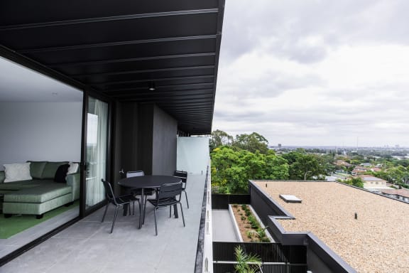 a balcony with a table and chairs and a view of the city