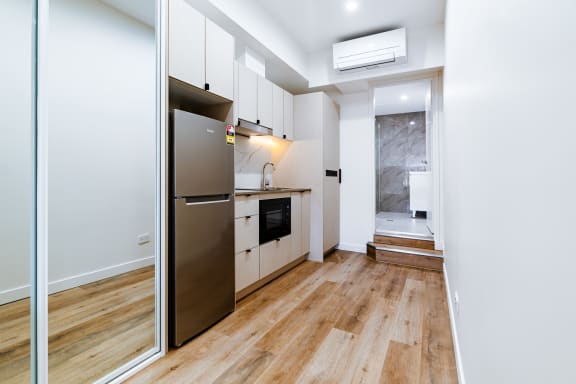 a small kitchen with stainless steel appliances and white cabinets