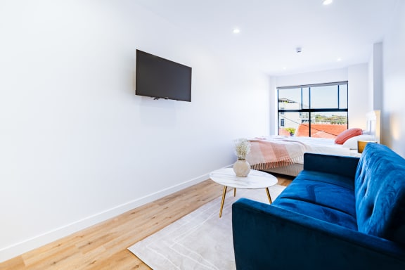 a living room with a blue couch and a tv