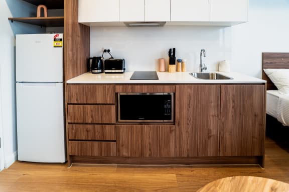 a kitchen with a sink and a refrigerator in a hotel room