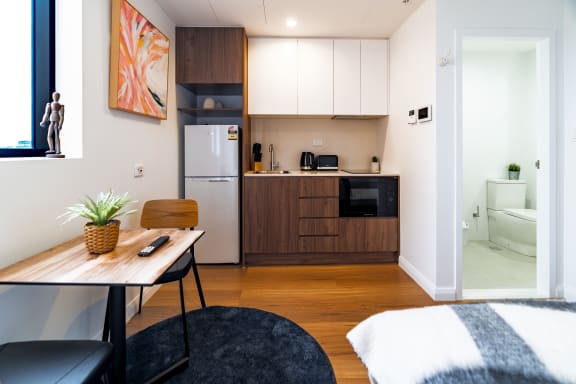 a kitchen and living room with a table and a chair