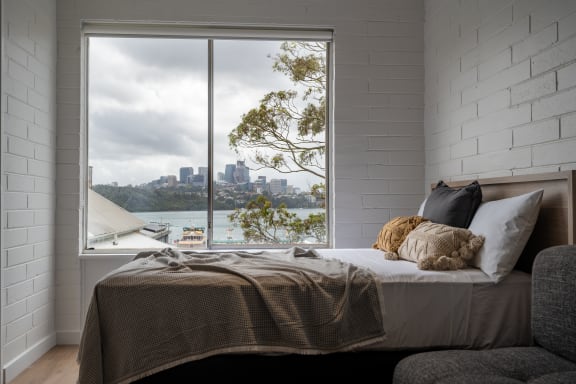 a bedroom with a bed and a window with a city view
