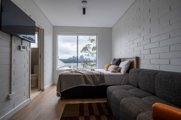 a bedroom with a bed and a window and a couch