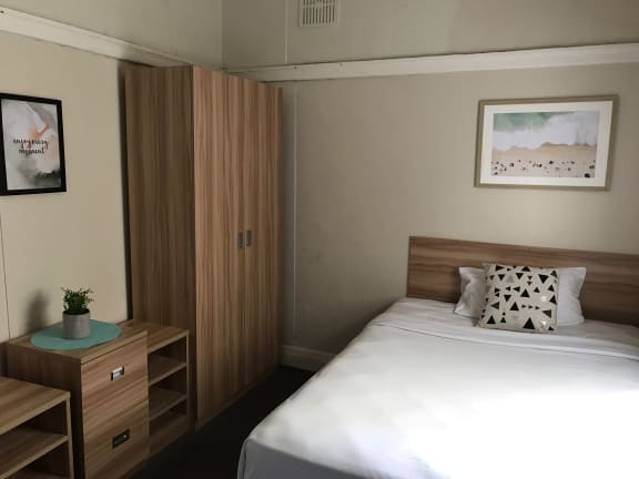 a small hotel room with a bed and a desk