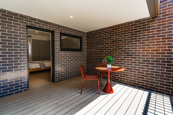 a room with a table and a chair in a brick wall