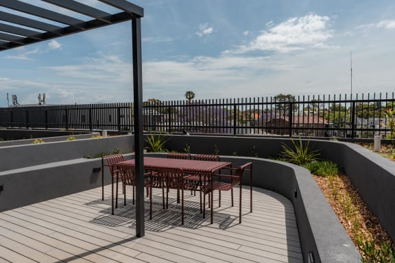 a patio with a table and chairs on a roof