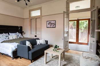 a bedroom with a bed and a couch and a coffee table