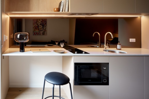 a kitchen with a counter top and a black stool