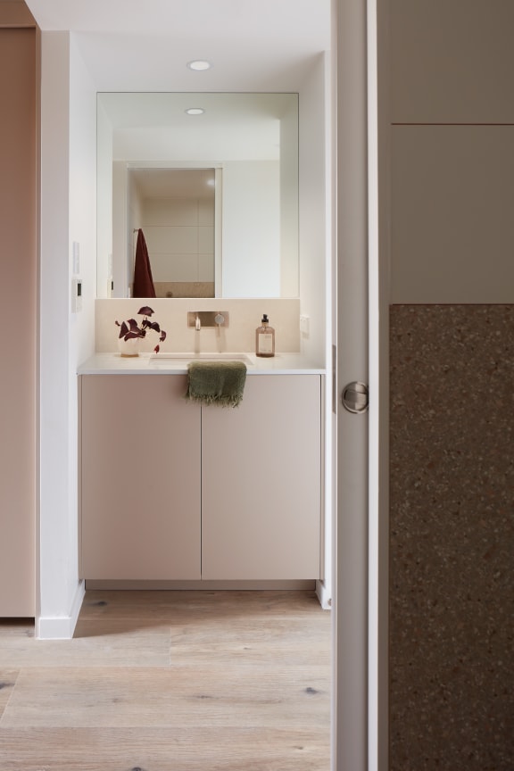 a bathroom with white cabinets and a sink and a mirror