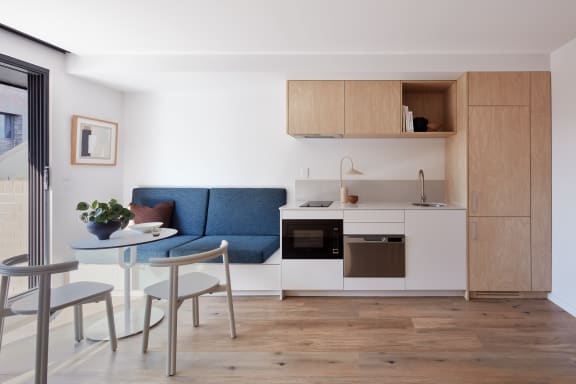 a small living room with a small kitchen and a table and chairs
