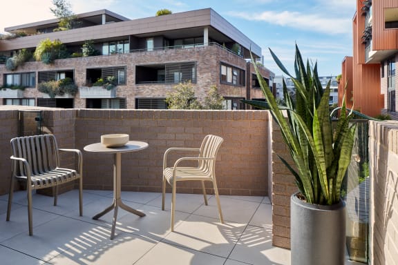 a balcony with a table and chairs and a brick wall