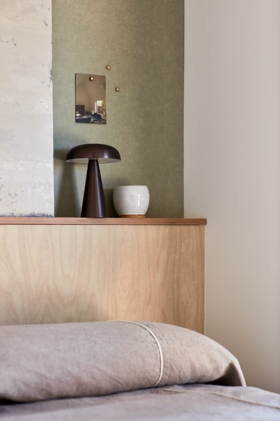 a bed with a lamp and a mirror on top of it