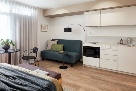 a small living room with a couch and a kitchen