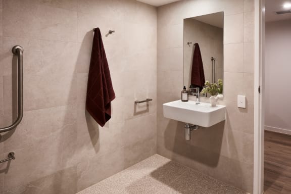 a bathroom with a sink and a mirror and a red towel