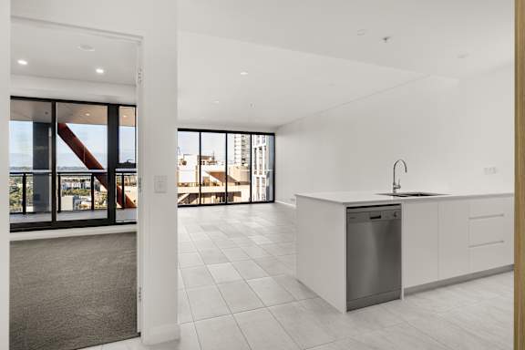A modern kitchen with a large island and a view of the city.