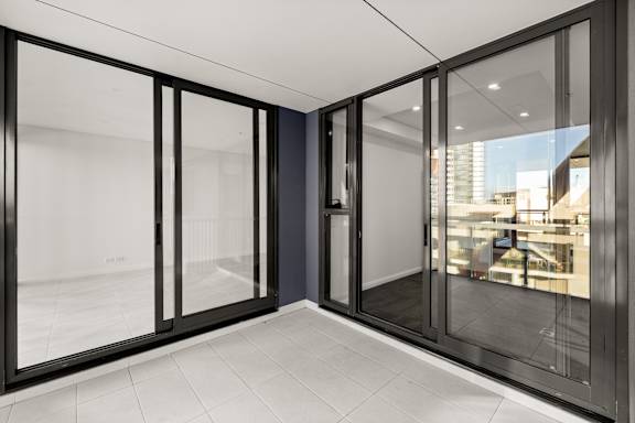 A room with a glass door and a white tiled floor.