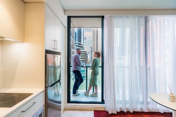 a man and a woman are standing in a glass door