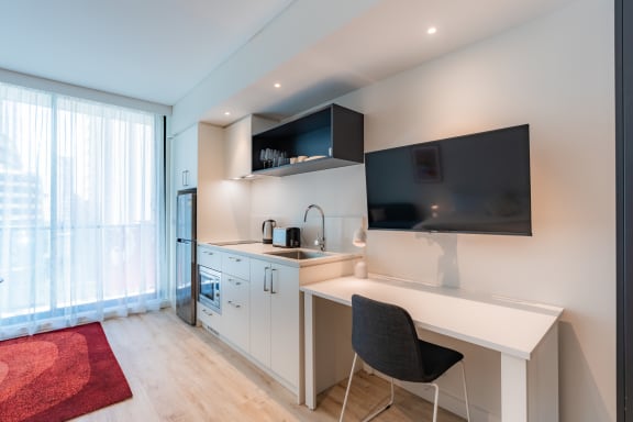 a kitchen with a desk and a chair and a window