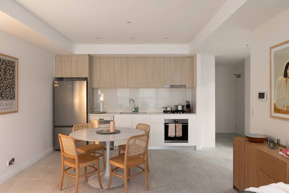 A modern kitchen with a dining table and chairs.