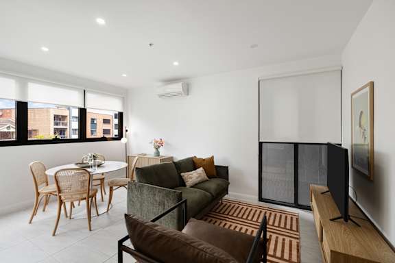 A living room with a brown chair and a green couch.