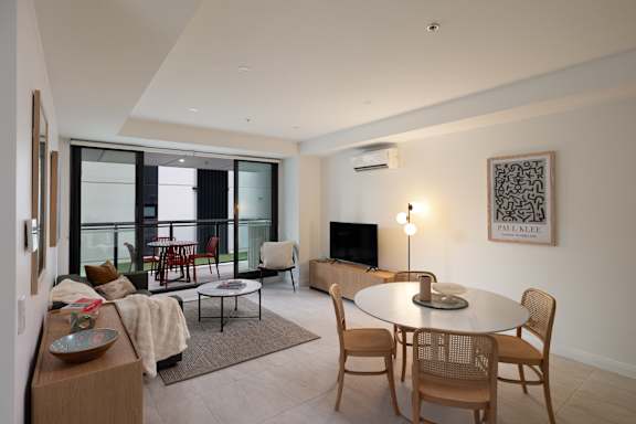 A modern living room with a glass door and a television.
