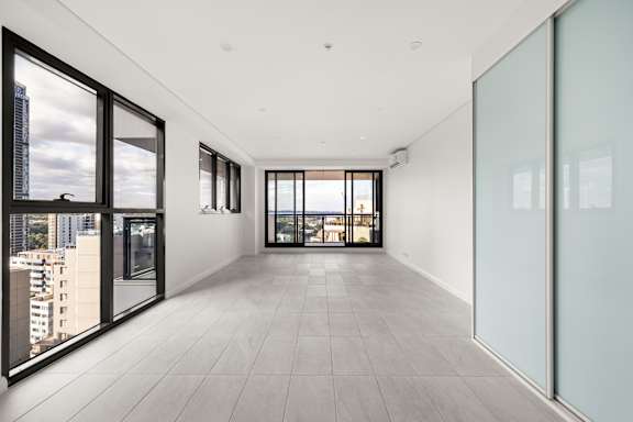 A spacious room with a view of the cityscape outside the large windows.