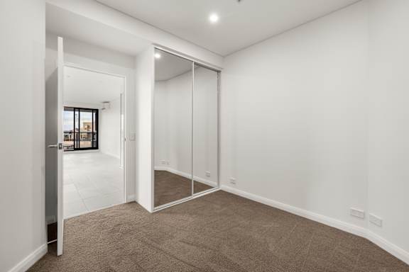 A room with a carpeted floor and a sliding glass door.