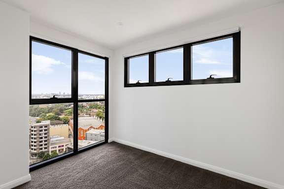 A room with a view of the city through large windows.