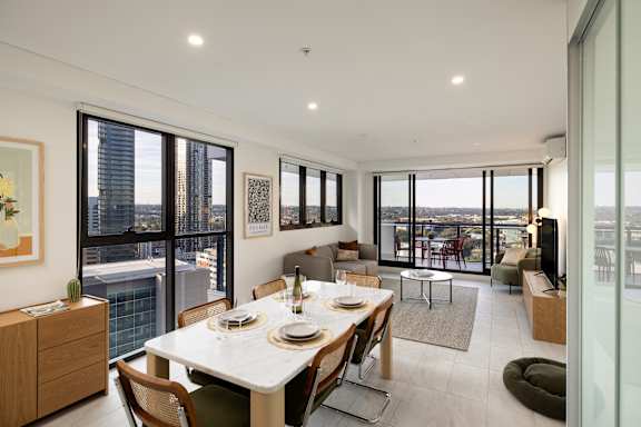 A dining room with a table set for two and a view of the city.