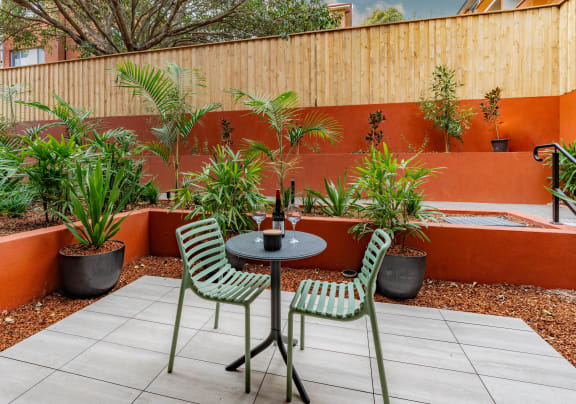 a small patio with a table and chairs and potted plants