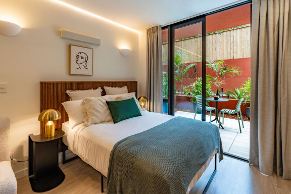 a bedroom with a bed and sliding glass doors to a patio