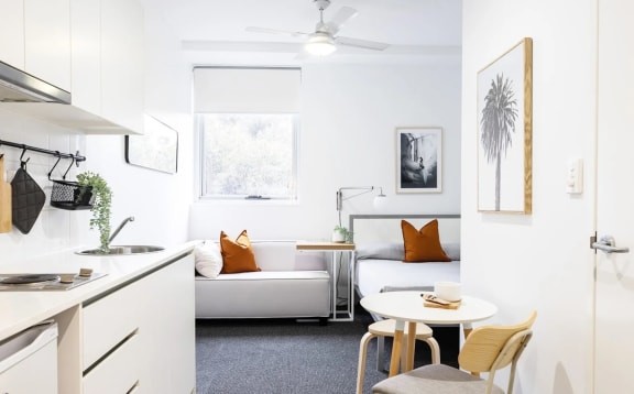 a living room with a couch and a table and a kitchen