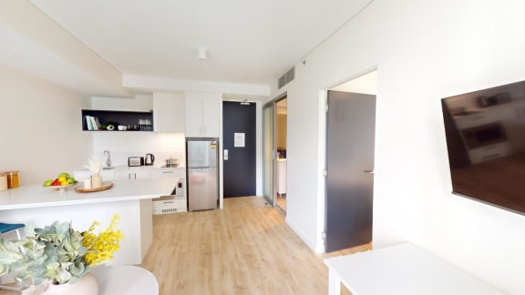 a living room and kitchen with a door to a hallway