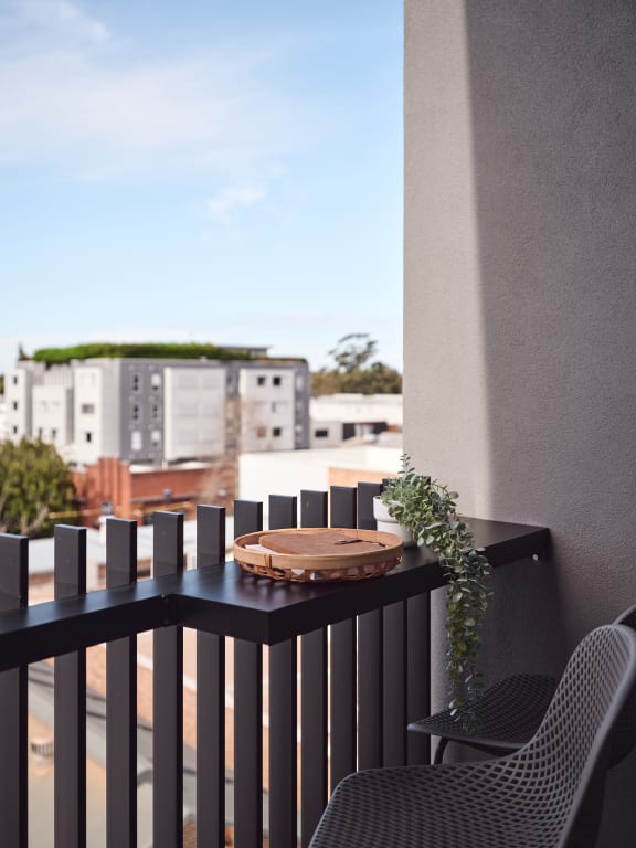 a balcony with a table and chairs and a view of buildings