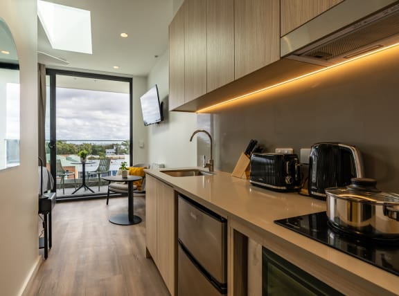 a kitchen with a counter top and a sink and a balcony