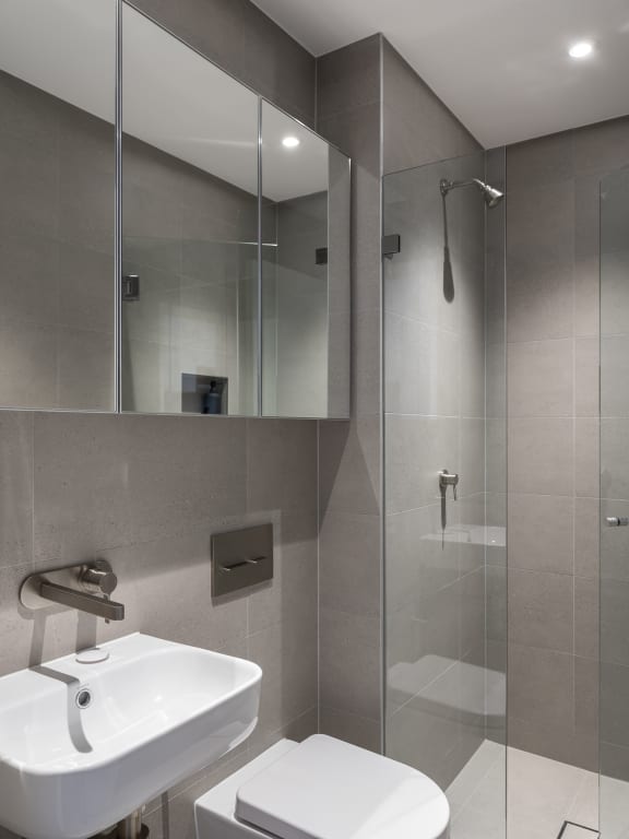 a small bathroom with a shower and a sink and a mirror