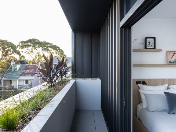 a bedroom has a balcony with a view of the city