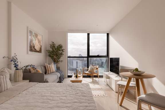A modern living room with a large window overlooking a cityscape.
