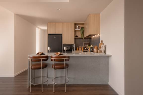 A kitchen with a bar stool and a counter.