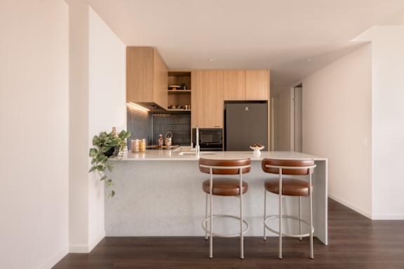 A kitchen with a bar stool and a counter.