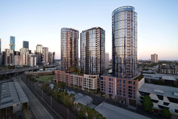 three tall skyscrapers with a city in the background