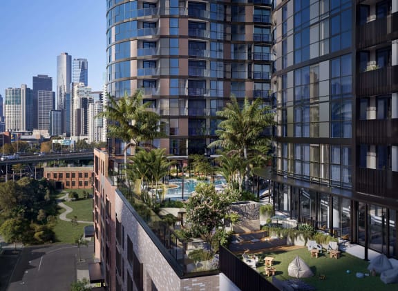 a view of the city from a balcony with palm trees and a pool